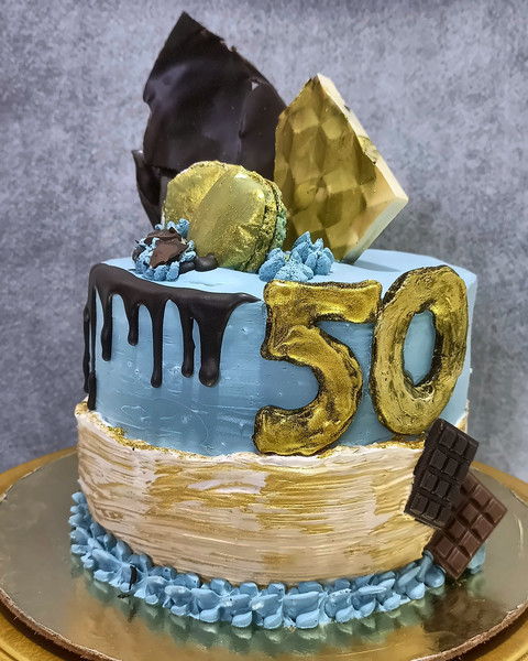 50th birthday drip cake with a gold 50 topper and chocolate shards